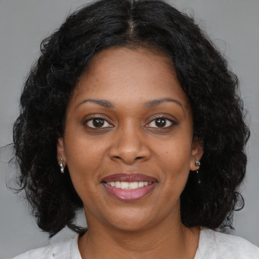 Joyful black young-adult female with medium  brown hair and brown eyes