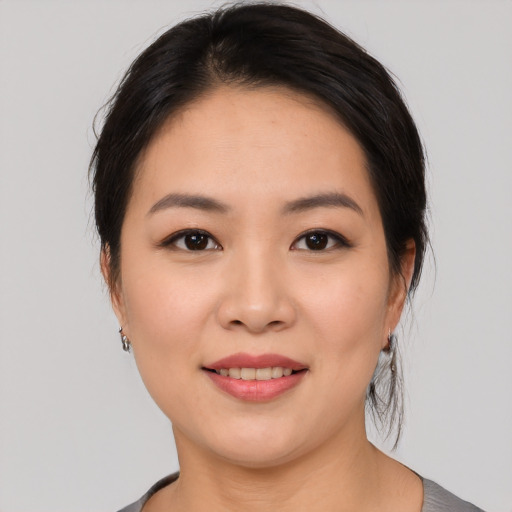Joyful asian young-adult female with medium  black hair and brown eyes
