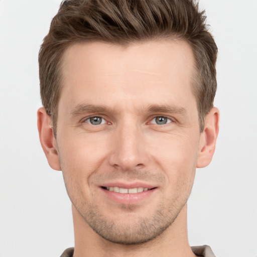 Joyful white young-adult male with short  brown hair and grey eyes