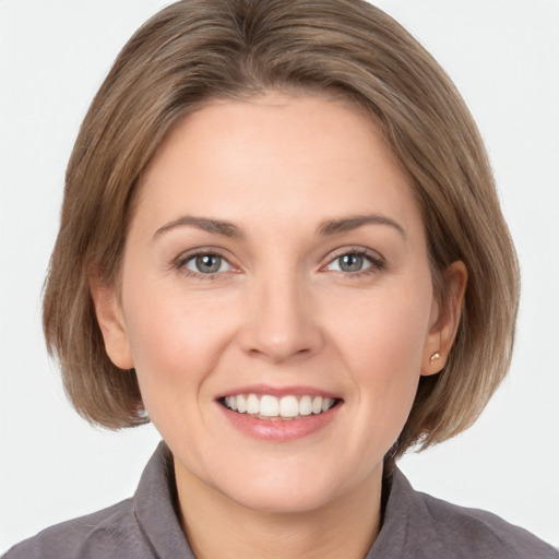 Joyful white young-adult female with medium  brown hair and grey eyes