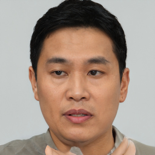 Joyful asian young-adult male with short  black hair and brown eyes