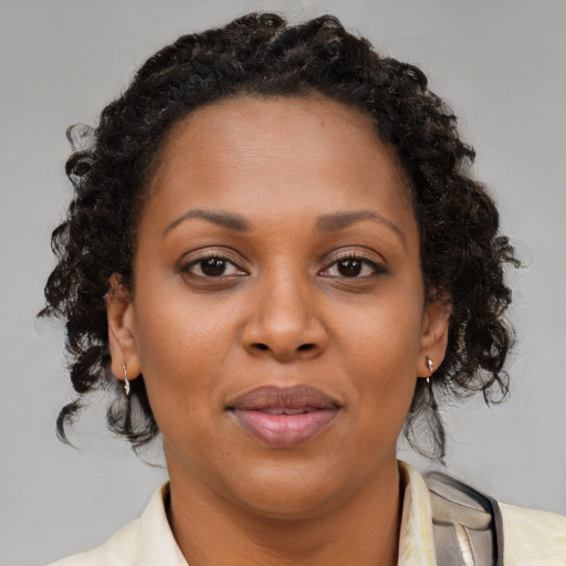 Joyful black adult female with medium  brown hair and brown eyes