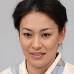 Joyful asian young-adult female with medium  brown hair and brown eyes