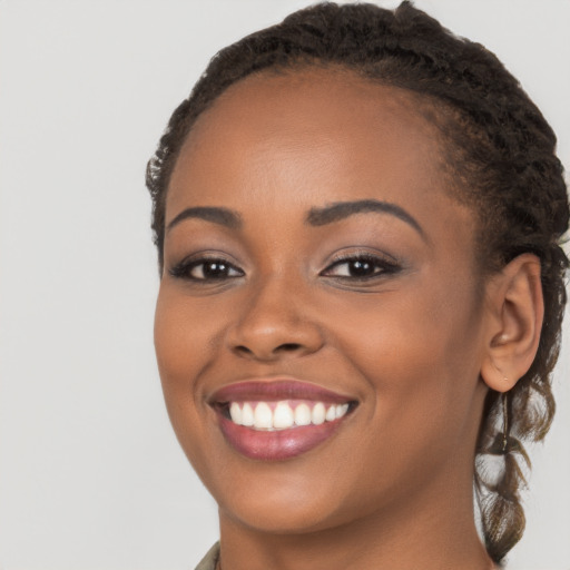 Joyful black young-adult female with long  brown hair and brown eyes