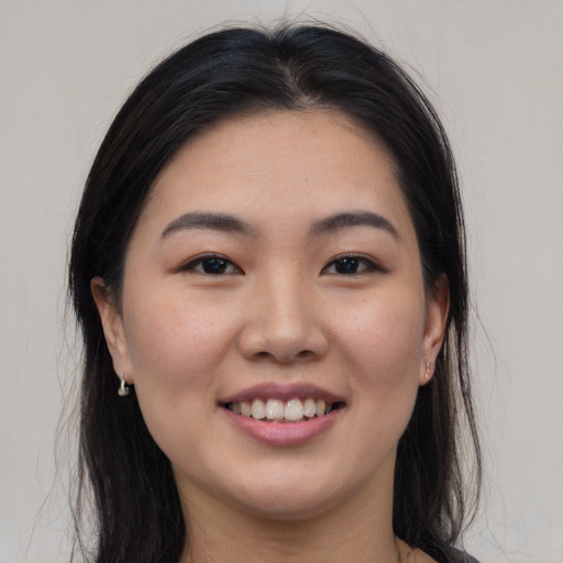 Joyful asian young-adult female with long  brown hair and brown eyes