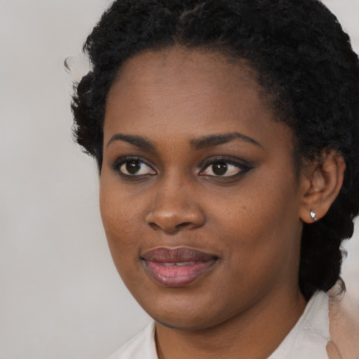 Joyful black young-adult female with short  black hair and brown eyes