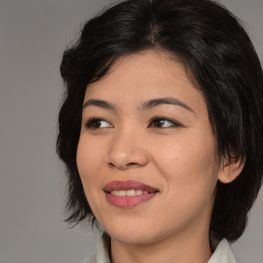 Joyful asian young-adult female with medium  black hair and brown eyes