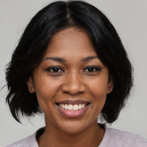 Joyful black young-adult female with medium  black hair and brown eyes