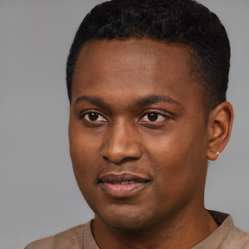 Joyful black young-adult male with short  black hair and brown eyes