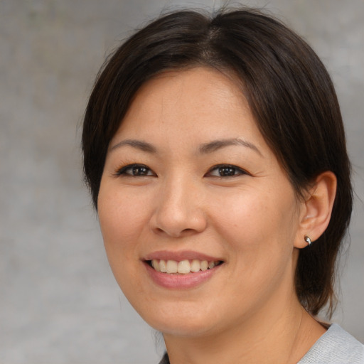 Joyful asian young-adult female with medium  brown hair and brown eyes