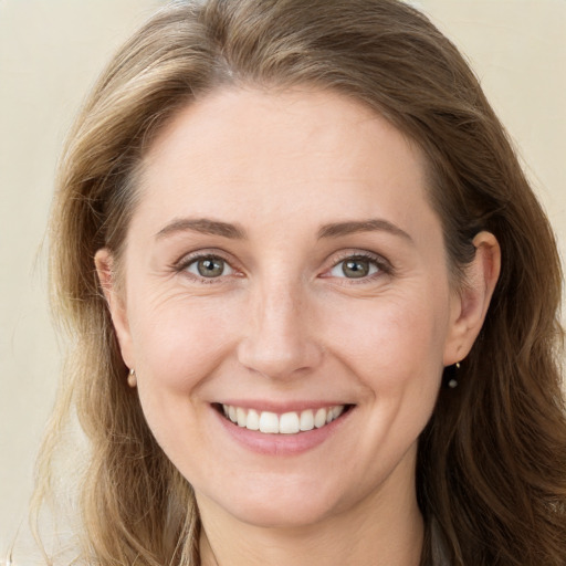 Joyful white young-adult female with long  brown hair and green eyes