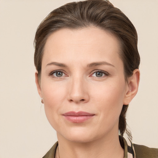 Joyful white young-adult female with medium  brown hair and grey eyes