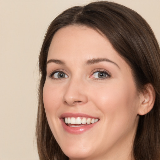 Joyful white young-adult female with long  brown hair and brown eyes