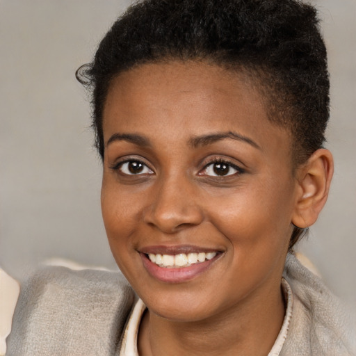 Joyful black young-adult female with short  brown hair and brown eyes