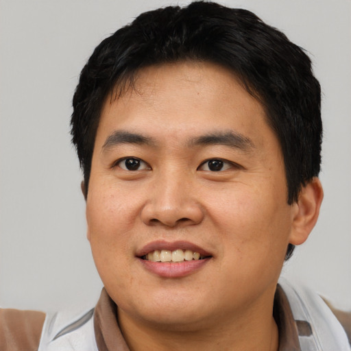 Joyful asian young-adult male with short  black hair and brown eyes