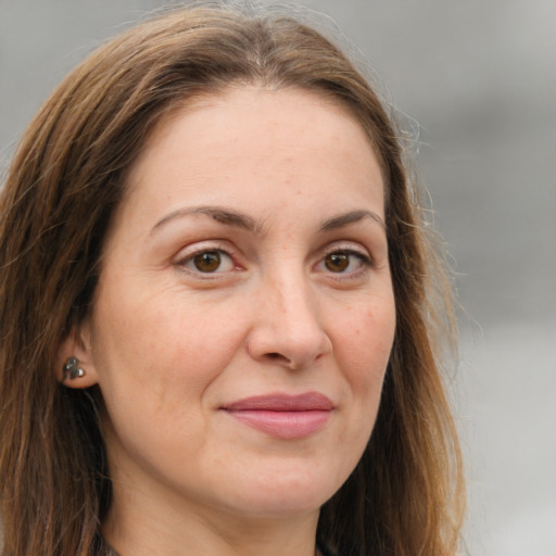 Joyful white adult female with long  brown hair and brown eyes