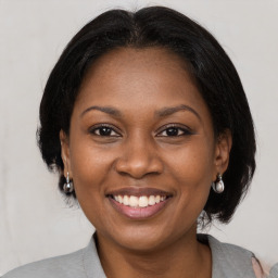 Joyful black adult female with medium  brown hair and brown eyes