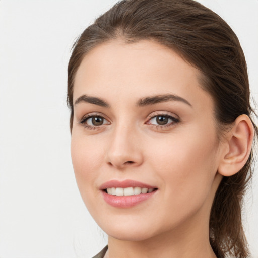 Joyful white young-adult female with long  brown hair and brown eyes