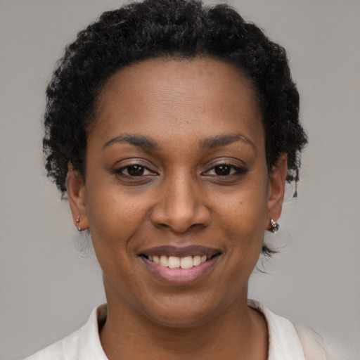 Joyful black young-adult female with short  brown hair and brown eyes