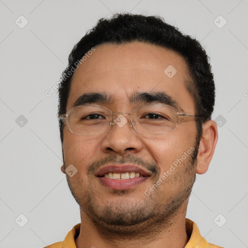 Joyful latino young-adult male with short  black hair and brown eyes