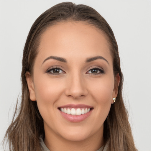 Joyful white young-adult female with long  brown hair and brown eyes