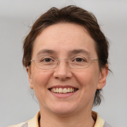 Joyful white adult female with medium  brown hair and grey eyes