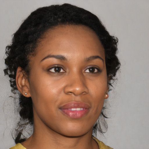 Joyful black young-adult female with long  brown hair and brown eyes