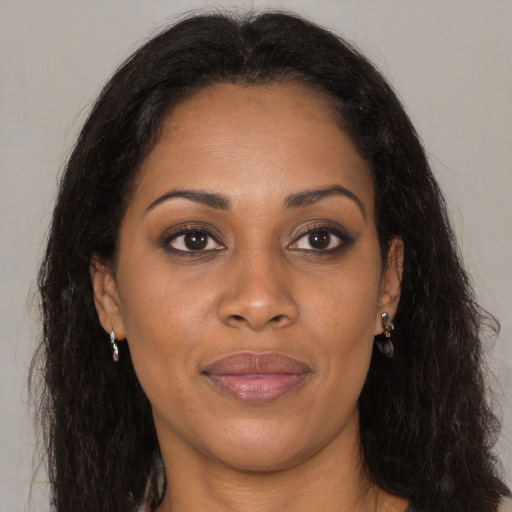 Joyful black young-adult female with long  brown hair and brown eyes