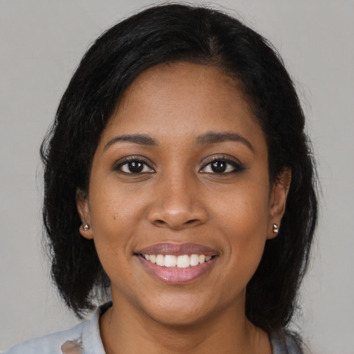 Joyful black young-adult female with medium  brown hair and brown eyes