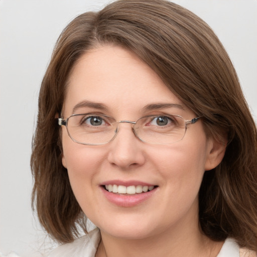 Joyful white adult female with medium  brown hair and green eyes