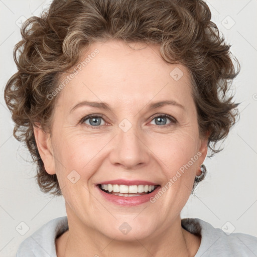 Joyful white adult female with medium  brown hair and blue eyes