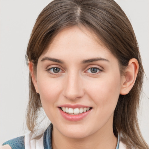 Joyful white young-adult female with medium  brown hair and grey eyes