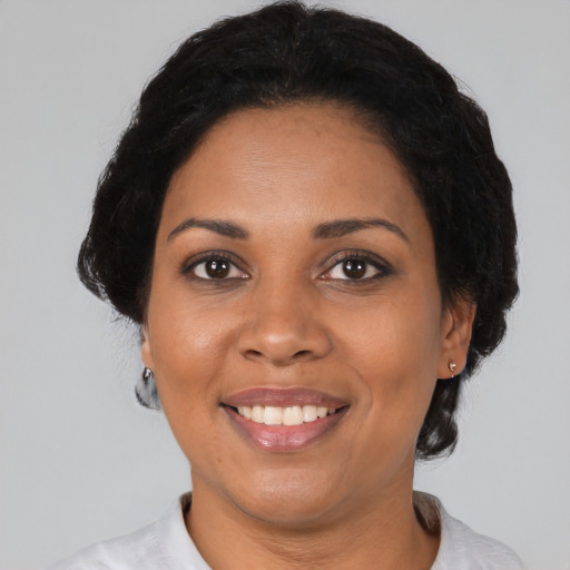 Joyful black adult female with medium  black hair and brown eyes