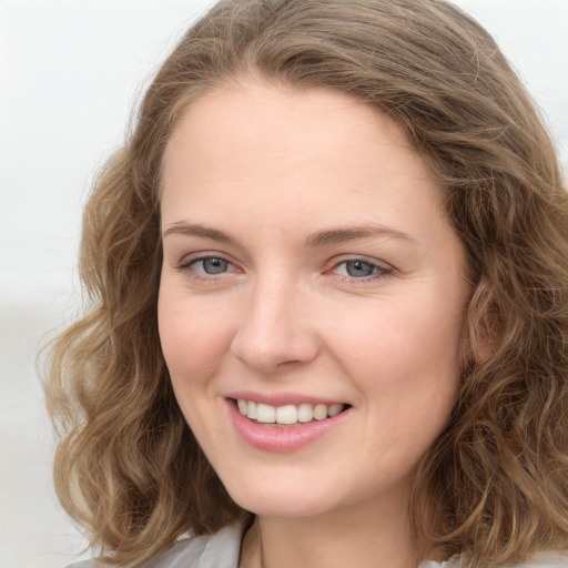 Joyful white young-adult female with long  brown hair and blue eyes