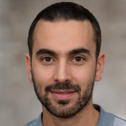 Joyful white young-adult male with short  black hair and brown eyes