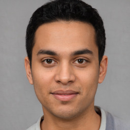 Joyful latino young-adult male with short  black hair and brown eyes