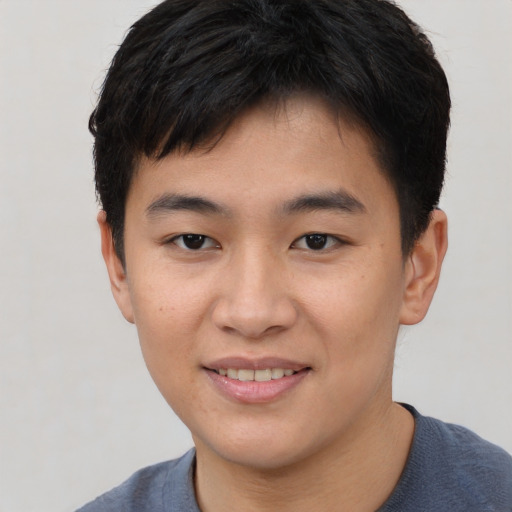 Joyful asian young-adult male with short  brown hair and brown eyes