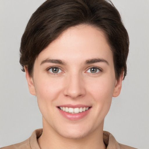 Joyful white young-adult female with short  brown hair and grey eyes