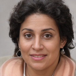 Joyful white adult female with long  brown hair and brown eyes