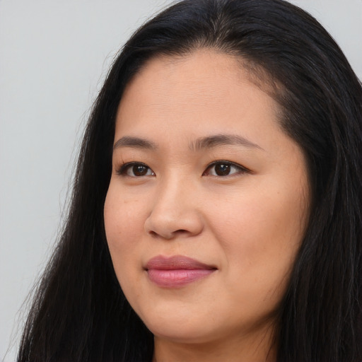 Joyful asian young-adult female with long  brown hair and brown eyes