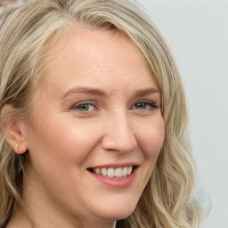 Joyful white young-adult female with long  brown hair and blue eyes