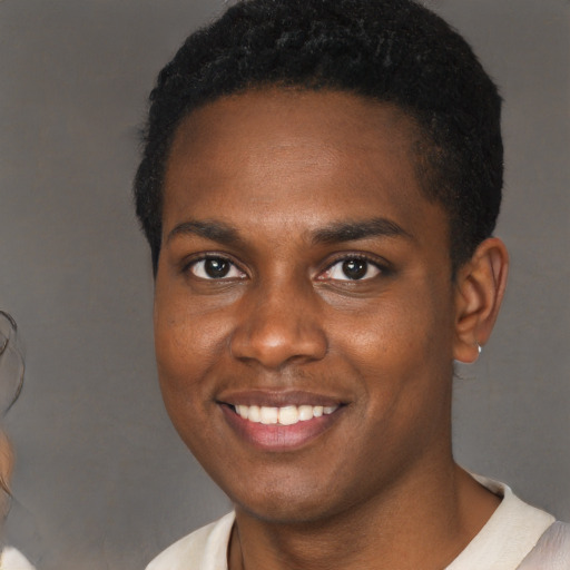 Joyful black young-adult male with short  brown hair and brown eyes