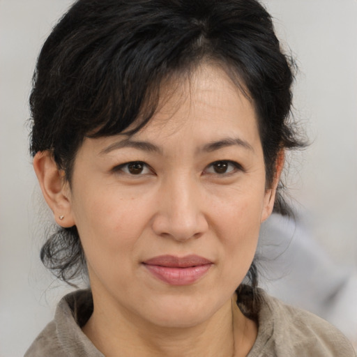 Joyful asian adult female with medium  brown hair and brown eyes