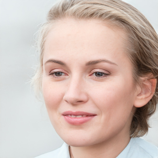 Joyful white young-adult female with medium  brown hair and blue eyes