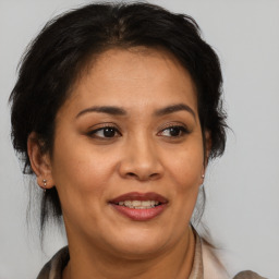 Joyful latino adult female with medium  brown hair and brown eyes