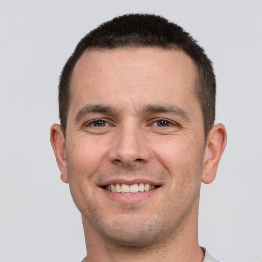 Joyful white young-adult male with short  brown hair and brown eyes