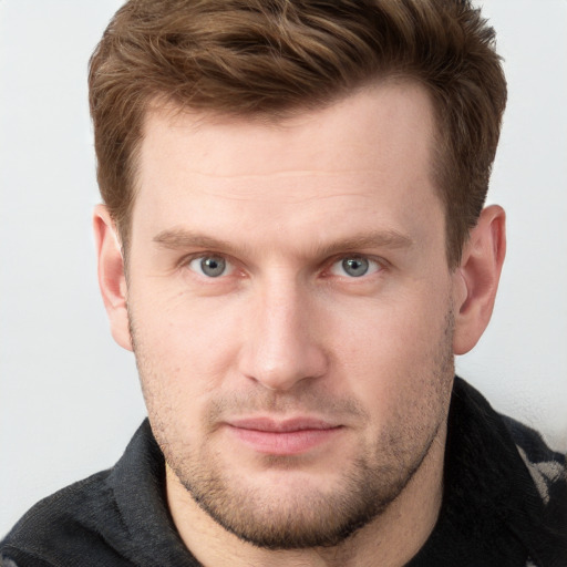 Joyful white young-adult male with short  brown hair and grey eyes