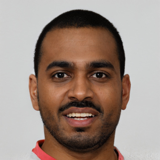 Joyful black young-adult male with short  black hair and brown eyes