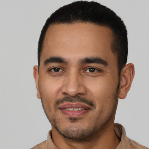 Joyful latino young-adult male with short  black hair and brown eyes