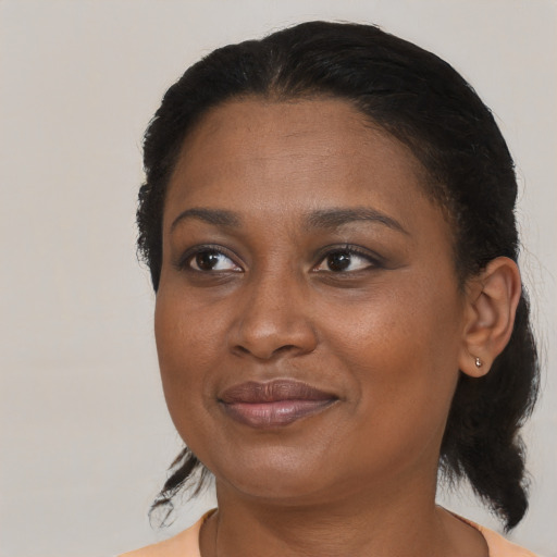 Joyful black adult female with medium  black hair and brown eyes